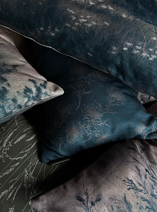 Closeup of a pile of assorted decorative pillows featuring select original artwork by Linsey Gray printed on quality performance linen fabric.