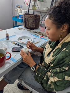 Woman sculpting a clay face during a Sacred Art & Story workshop near Asheville